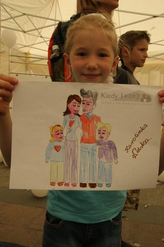 Dziewczynka z rysunkiem rodziny.