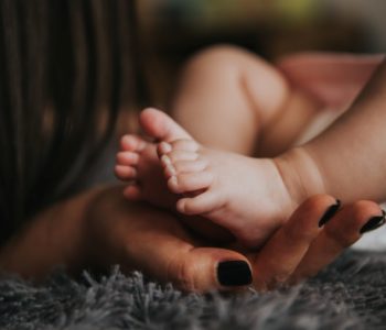 stopy dziecka na dłoni mamy