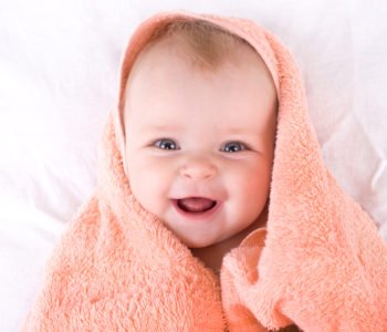 Uśmiechnięte dziecko owinięte w ręcznik