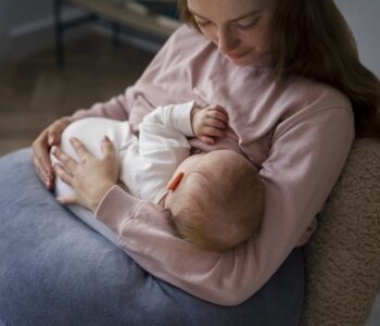 Bebilon 2. Mama trzyma niemowlę na ręku.