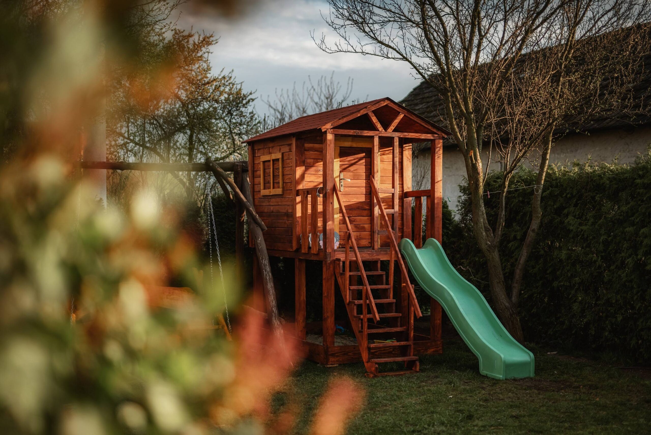Drewniany domek ogrodowy dla dzieci ze zjeżdżalnią