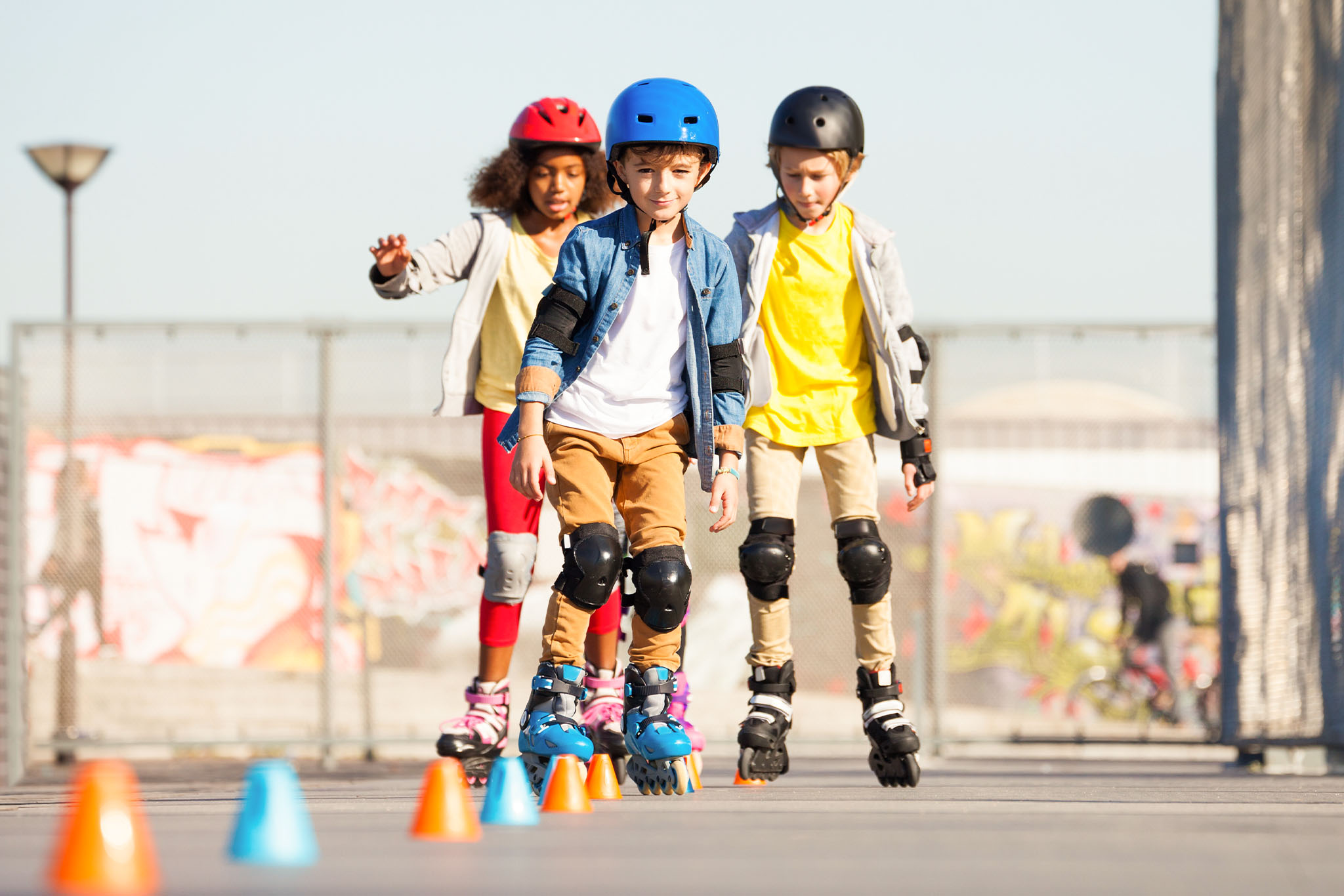Dzieci uczące się manewrować na rolkach - zdjęcie.
