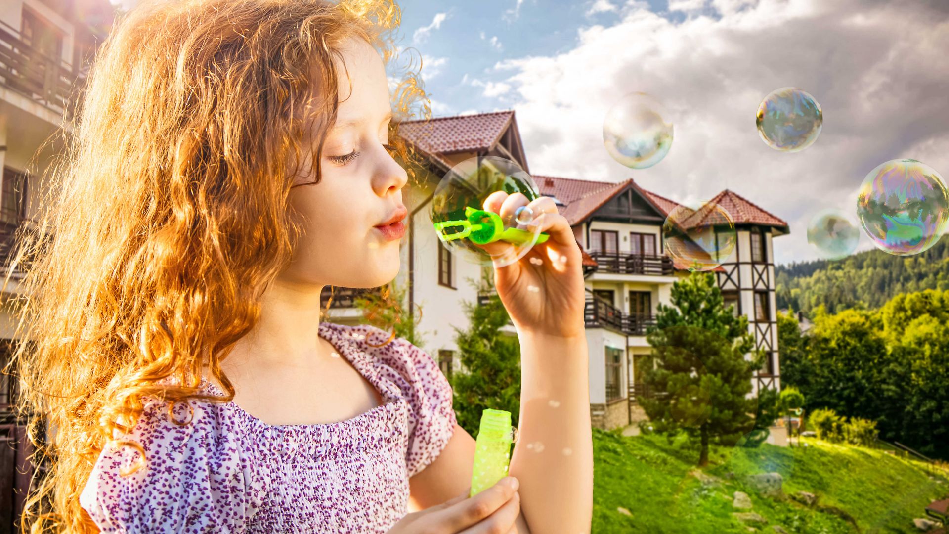 Dziewczynka cieszy się wiosenną atmosferą w ogrodzie Hotelu Dziki Potok podczas rodzinnego pobytu w Karpaczu